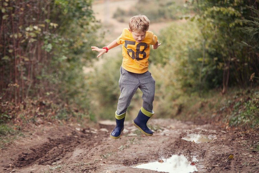 Jongen springen modderplas duinen