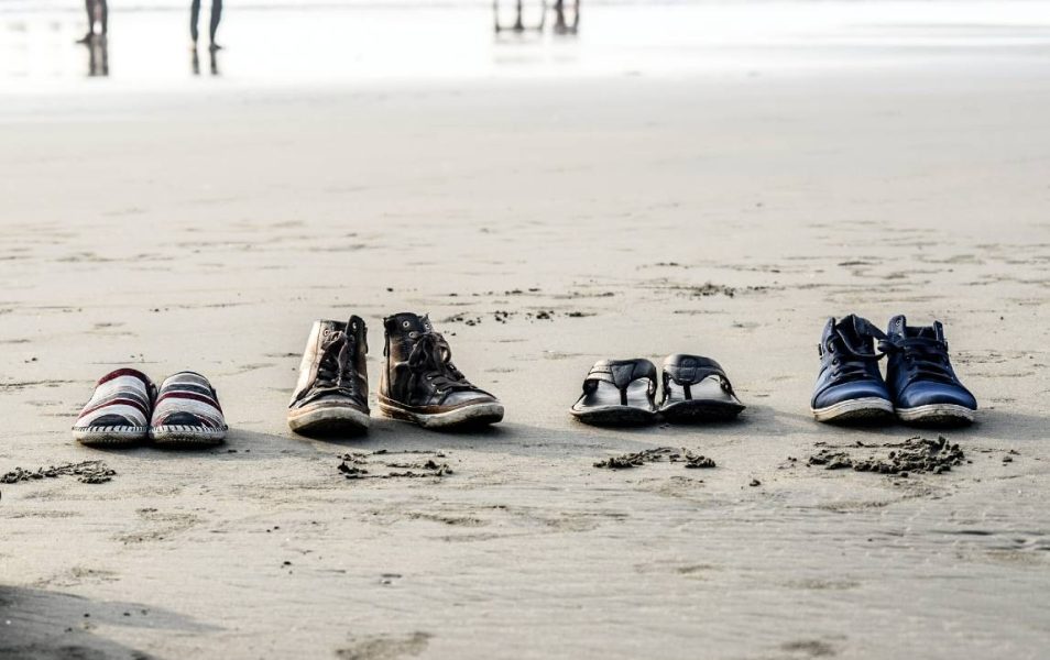 Verlaten schoenen van een gezin op het strand