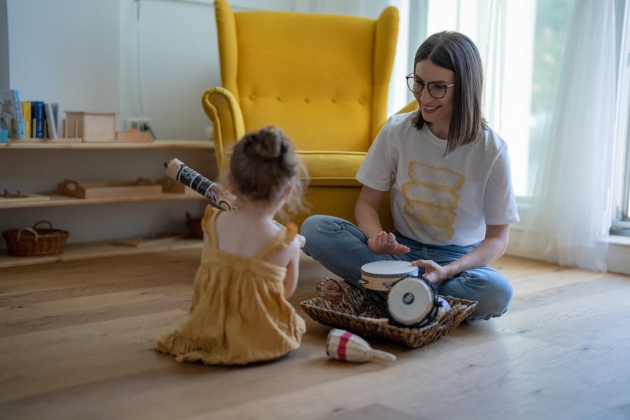 Behandelaar en kind spelen op de grond