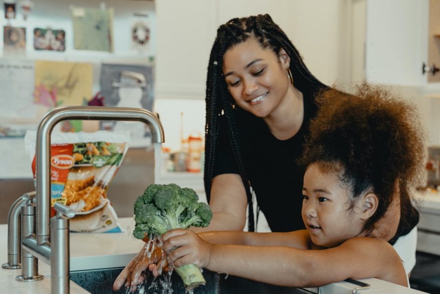 Meisje en jonge vrouw koken samen