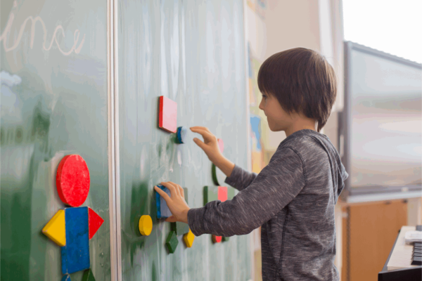 Jongen schrijft op een schoolbord